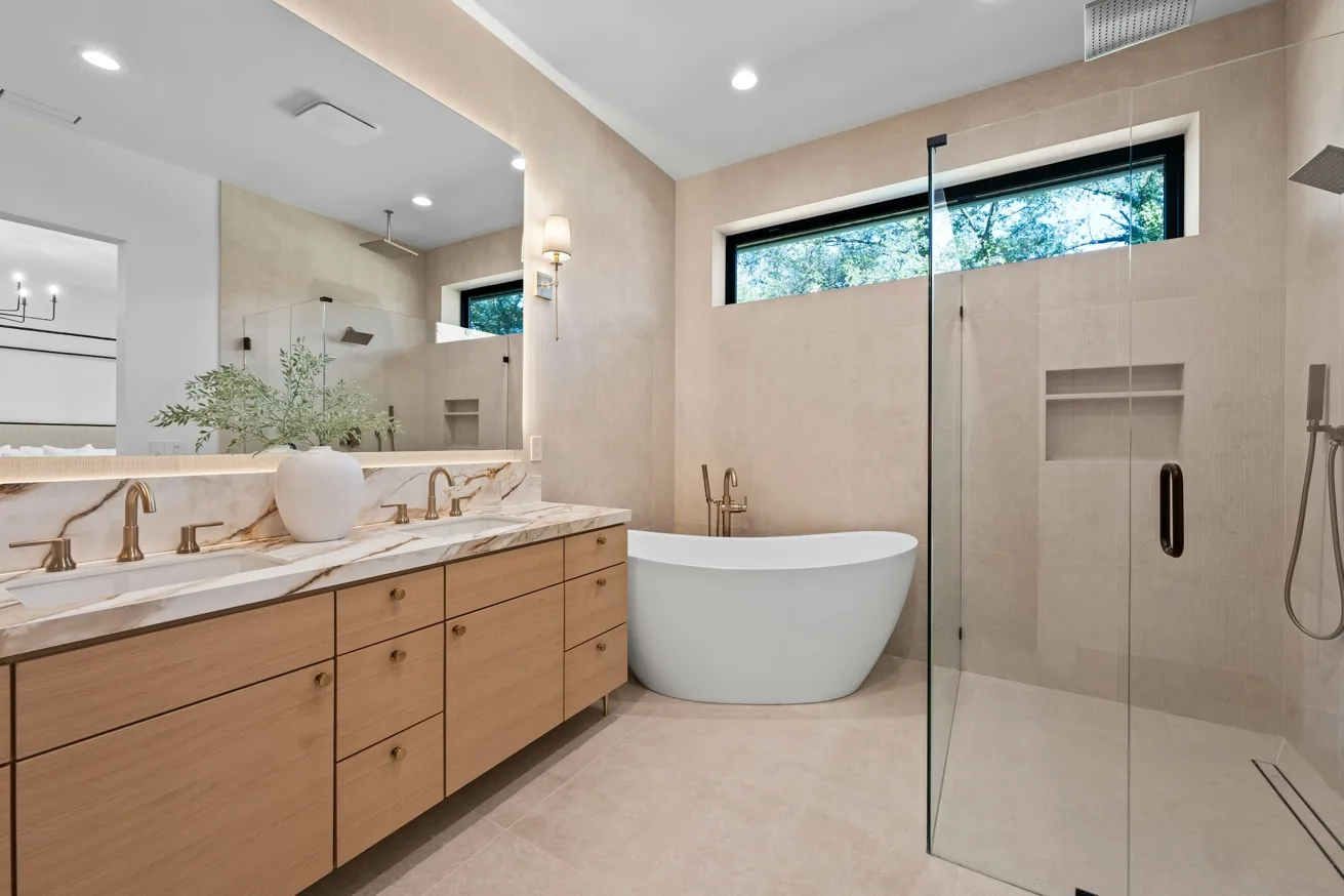 Elegant marble bathroom with warm wood vanity and refined brass detailing
